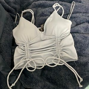 A pale blue crop top with embedded cups and tie knots